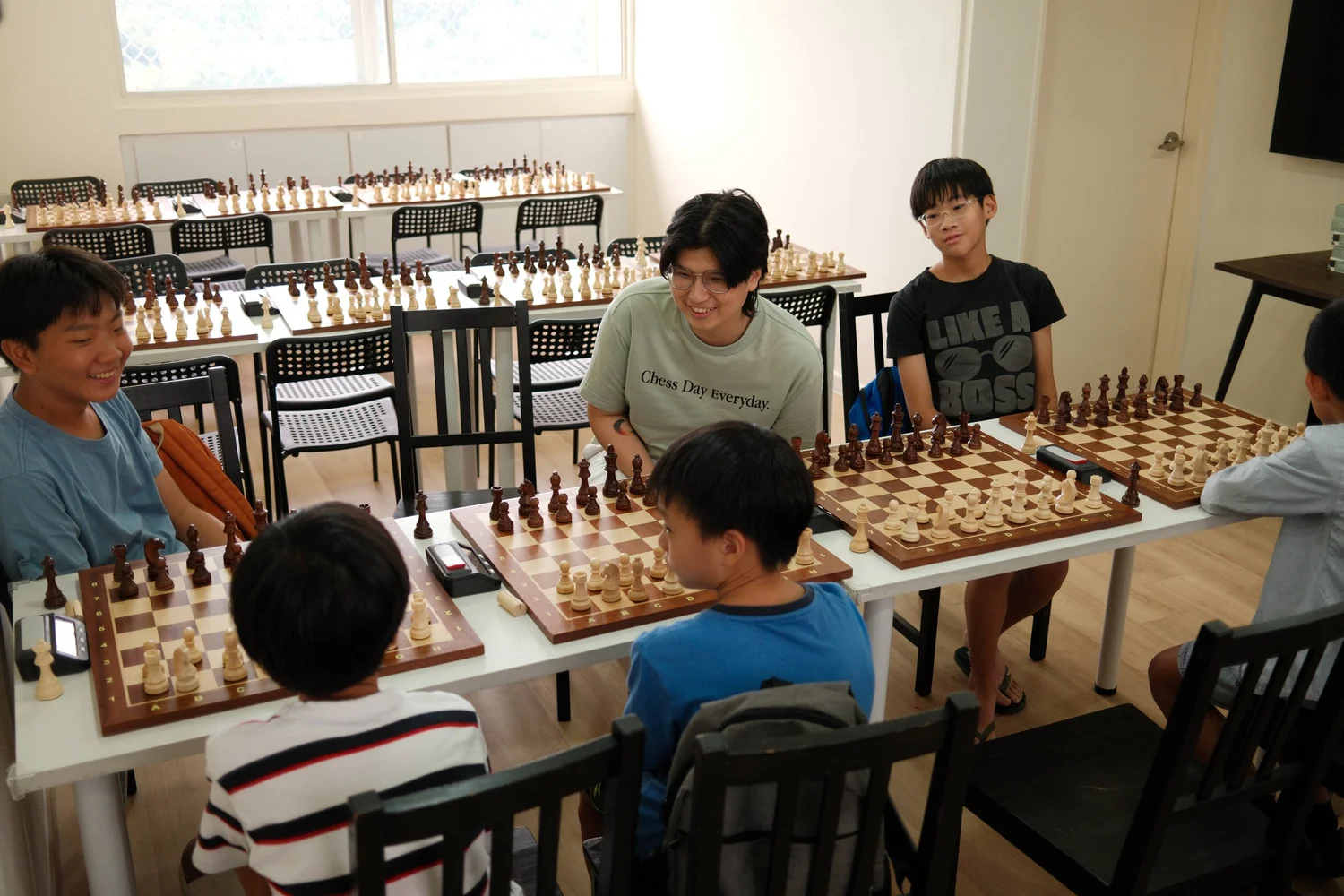 A coach and children at chessboards during a Chess.sg group class