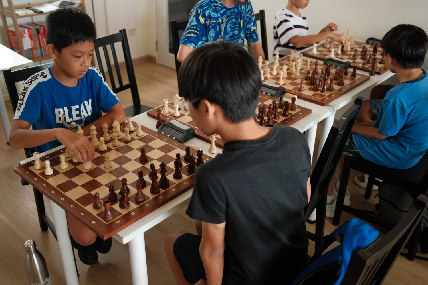 Children playing chess against each other at a Chess.sg holiday camp