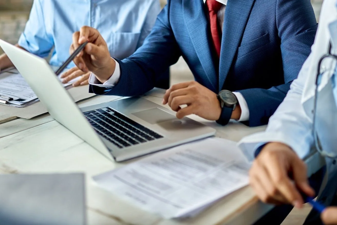 Consultant and healthcare workers using laptop on a meeting in the office.
