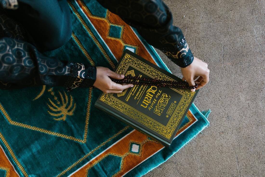Beads on the Quran on a prayer mat