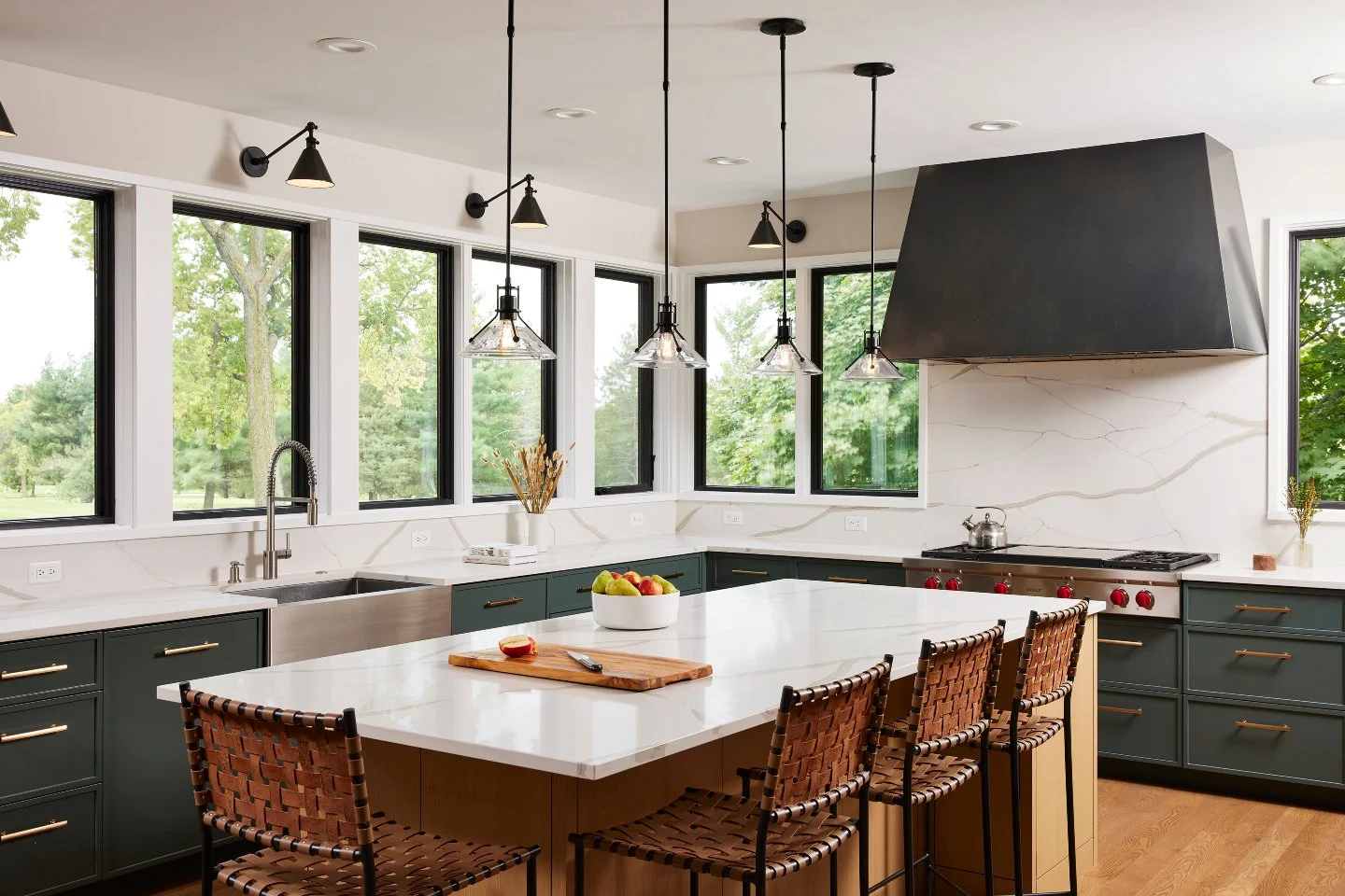 The Fairway Residence kitchen prioritizes natural light through large windows on two sides of the space, offering views of the exterior landscape.

An adjacent pantry allows the main kitchen space to feel open, while providing additional storage near