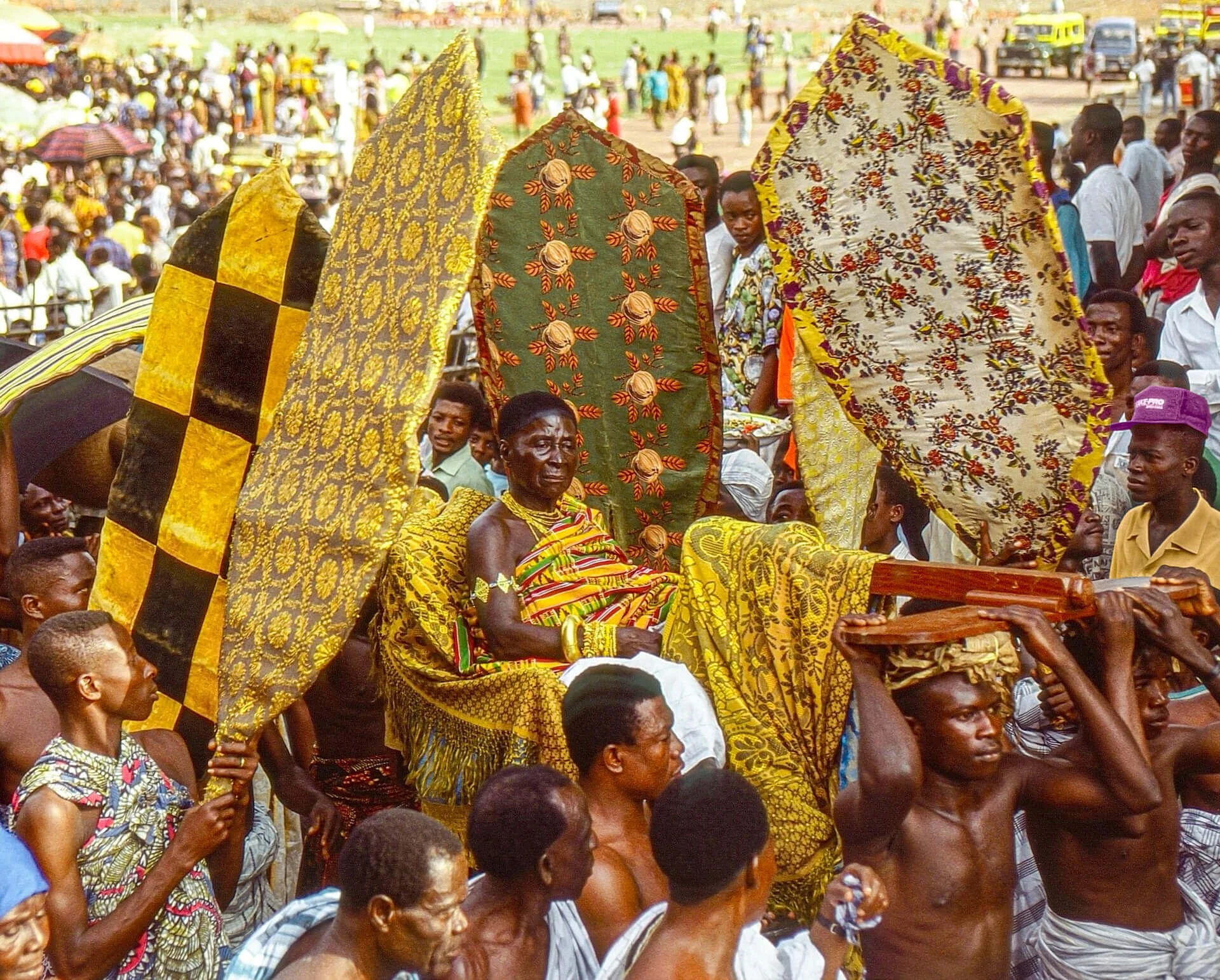 The Asantehemaa (Queen Mother) Nana Afua Kobi and her fan bearers, Ghana. Unknown photographer. (n.d.). The Asantehemaa (Queen Mother) Nana Afua Kobi and her fan bearers, Ghana [Photograph]. Africa Online Museum. https://africaonlinemuseum.org/map/gh