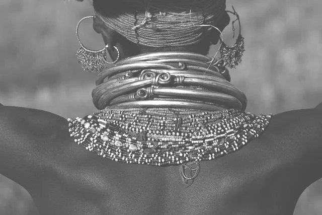 Turkana Woman from the Lake Turkana region adorned with traditional metal neck collars and intricate beaded necklaces. Photographed by David Ballam in Kenya.