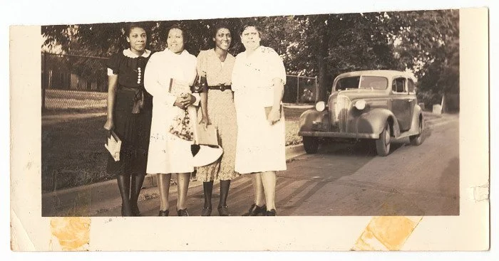 The Princetta R. Newman Collection of Family Photographs, Tulsa, Oklahoma. (n.d.-d). Photographic print of four women standing in a street, ca. 1940. Collection of the Smithsonian National Museum of African American History and Culture, Gift of Princ