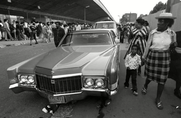 Notting Hill Carnival: The Early Years: Revellers make their way down the carnival route. Photographed by Richard Braine.