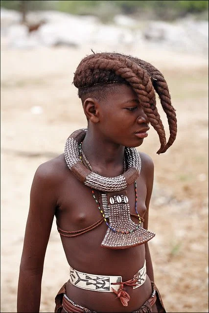 Himba boy with traditional hairstyle. Image from Peter Schnurman via Trip Down Memory Lane blog.