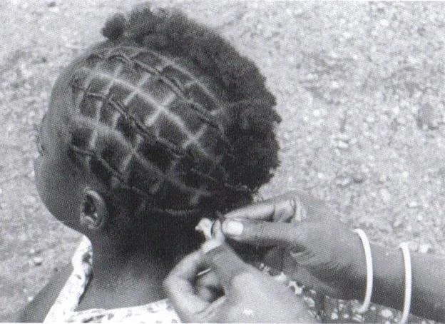 Traditional congo hairstyle known as "nwani" or "nyoni" from Kisangani, Congo, featuring intricate grid-like braiding patterns. Photo taken in West Africa, rights reserved to Afrika Museum, Berg en Dal.