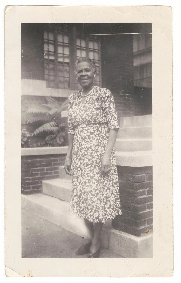 The Princetta R. Newman Collection of Family Photographs, Tulsa, Oklahoma. (n.d.). Photographic print of Irene Banks standing in front of a brick building, mid 20th century.  Collection of the Smithsonian National Museum of African American History a