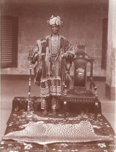 Traditional Agbada ceremonial robes and a beaded royal crown worn by Oba Ladapo Ademola II, the Alake of Egbaland, in Abeokuta, Nigeria, around 1923.