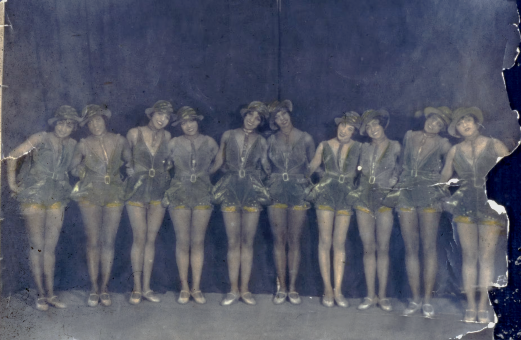 A colorized group portrait of members of a chorus line in Harlem, New York, circa 1920s. Photographed by Anthony Barboza.