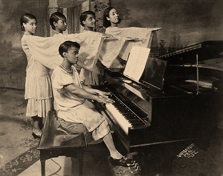 Young Students Rehearsing with Their Piano Instructor, photographed by James Van Der Zee (1932).