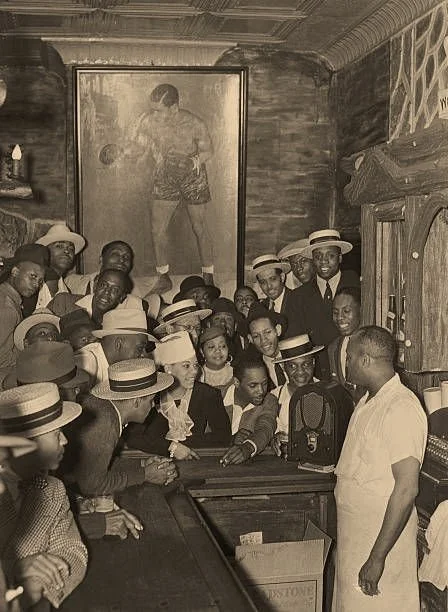 Harlem bar patrons listening to the radio broadcast of  Joe Louis versus Max Schmeling in their heavyweight title rematch in 1938.