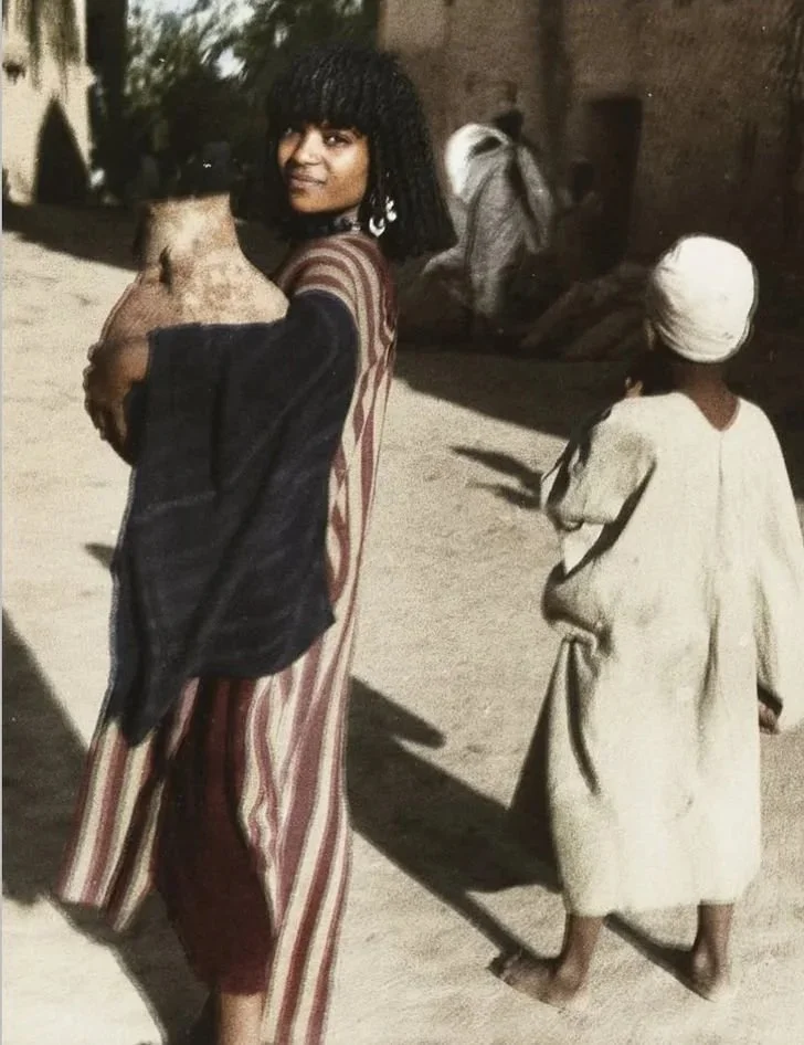 A Siwan woman wearing a traditional striped kaftan, photographed by Brigitte Schiffer, 1934.