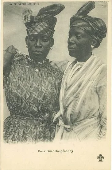 Two Guadeloupean women wearing madras headwraps and traditional Creole dresses.
