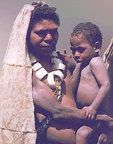 Mother with her child at the Mt. Hagen Show. She wears a bark cloth (tapa) cape and cut shell necklace. Copyright Scott Perry, 1997.

