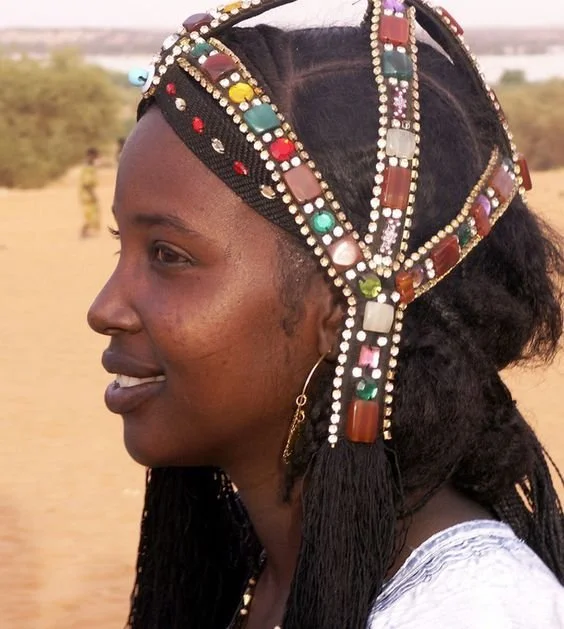 Chad woman wearing a traditional headpiece adorned with colorful agate stones and glass beads, which serves as a protective amulet or fertility charm.