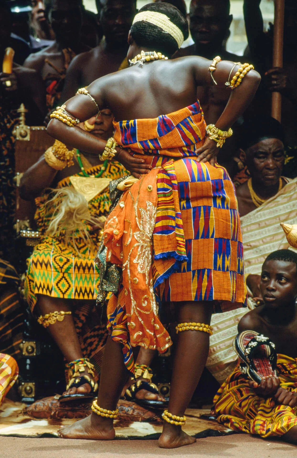 Ashanti Female Court Dancer, Ghana. This image captures an Ashanti female court dancer performing before the royal assembly during a ceremonial gathering. Such performances unfold within a festive atmosphere where paramount chiefs engage their commun