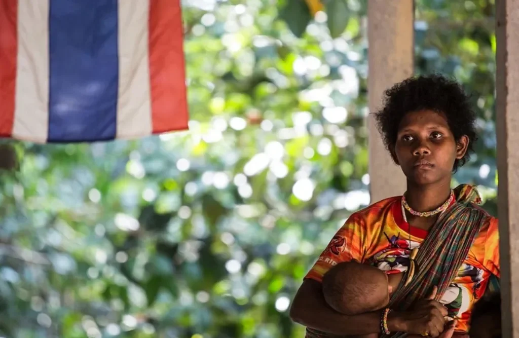 A portrait of a Maniq woman breastfeeding — Image via Livity.Blog