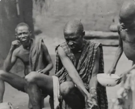 Titled elder Onyeso of Agukwu Nri washing hands for a rite before a shrine to Agwụ̀, a divinity of doctors (dibị̀à). Photographed by Northcote Thomas in 1911. MAA Cambridge.