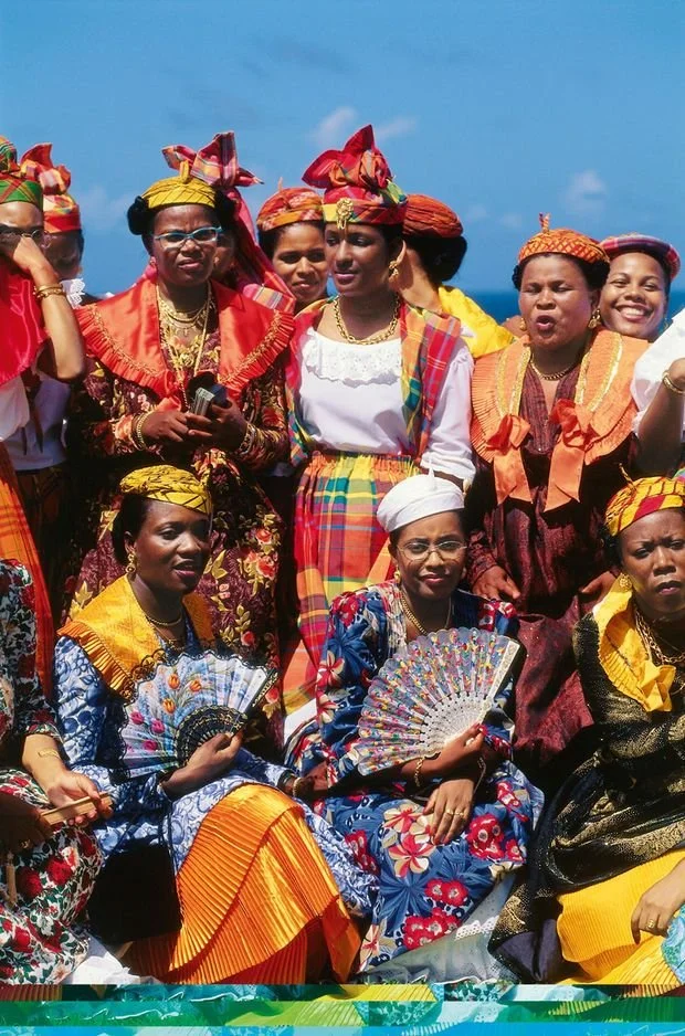 Women from Guadeloupe wearing colorful madras headwraps and traditional Creole dresses.
