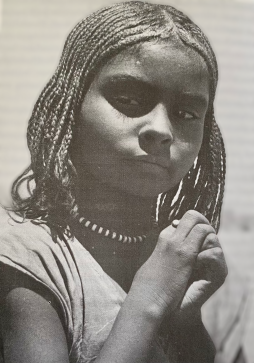 A young girl with hair braided in the mushat manner (Sisters under the Sun, Marjorie Hall and Bakhita Amin Ismail, 1981)