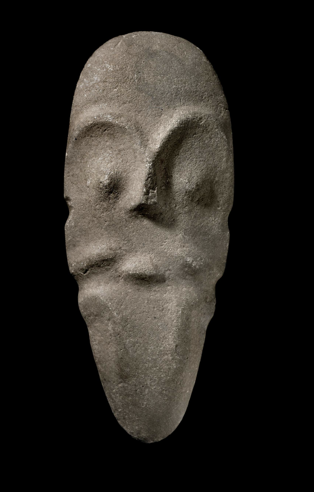 Axe or Wedge with Human Figure. Stone; Length 19.50 cm × Width 8 cm × Diameter 4 cm. Caribbean, Americas. This carved stone object, identified as an axe or wedge, features a possible anthropomorphic figure integrated into its form. Excavated in the C