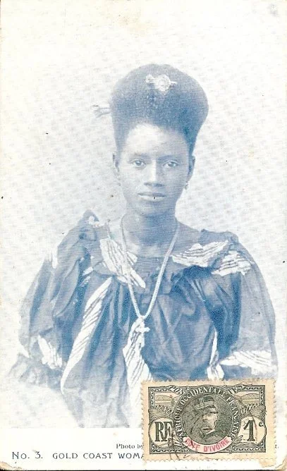 Woman from the African Coast photographed by F.W.H Arkhurst, with their hair swept high and adorned with gold ornament. Sourced from AdireAfricanTextiles.blogspot.com.