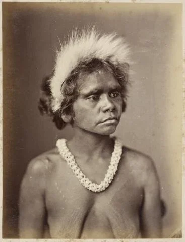 Photo of young woman, wearing fur headdress and a necklace