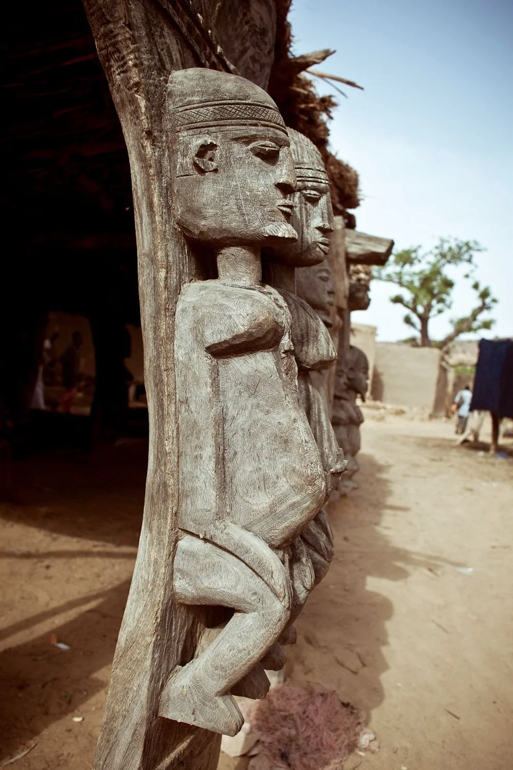 These are carved wooden figures supporting a Dogon togu na (men's meeting house) in Mali. 