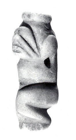 Figure Pendant. 10th–15th century. Taíno culture; Dominican Republic, Caribbean. Carved stone pendant (H. 5.1 cm [2 in]) representing a crouching anthropomorphic zemí figure, created by Taíno carvers using direct percussion and grinding to shape and 