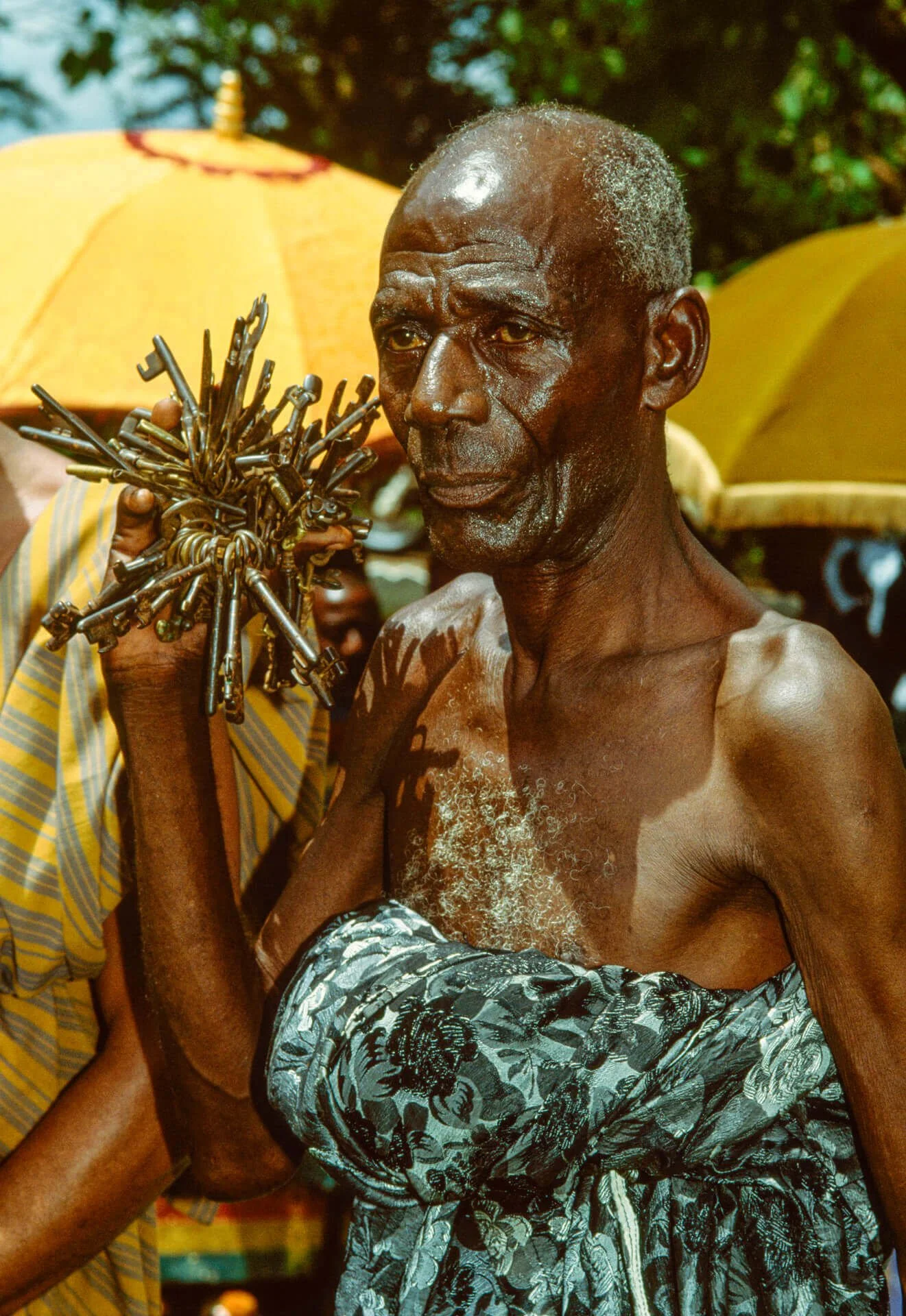 Ashanti Key Bearer showing the palace is locked and secure, Ghana. This image depicts an Ashanti Key Bearer holding a large cluster of keys, a powerful symbol of custodianship and security within the Ashanti palace. The keys represent that every door