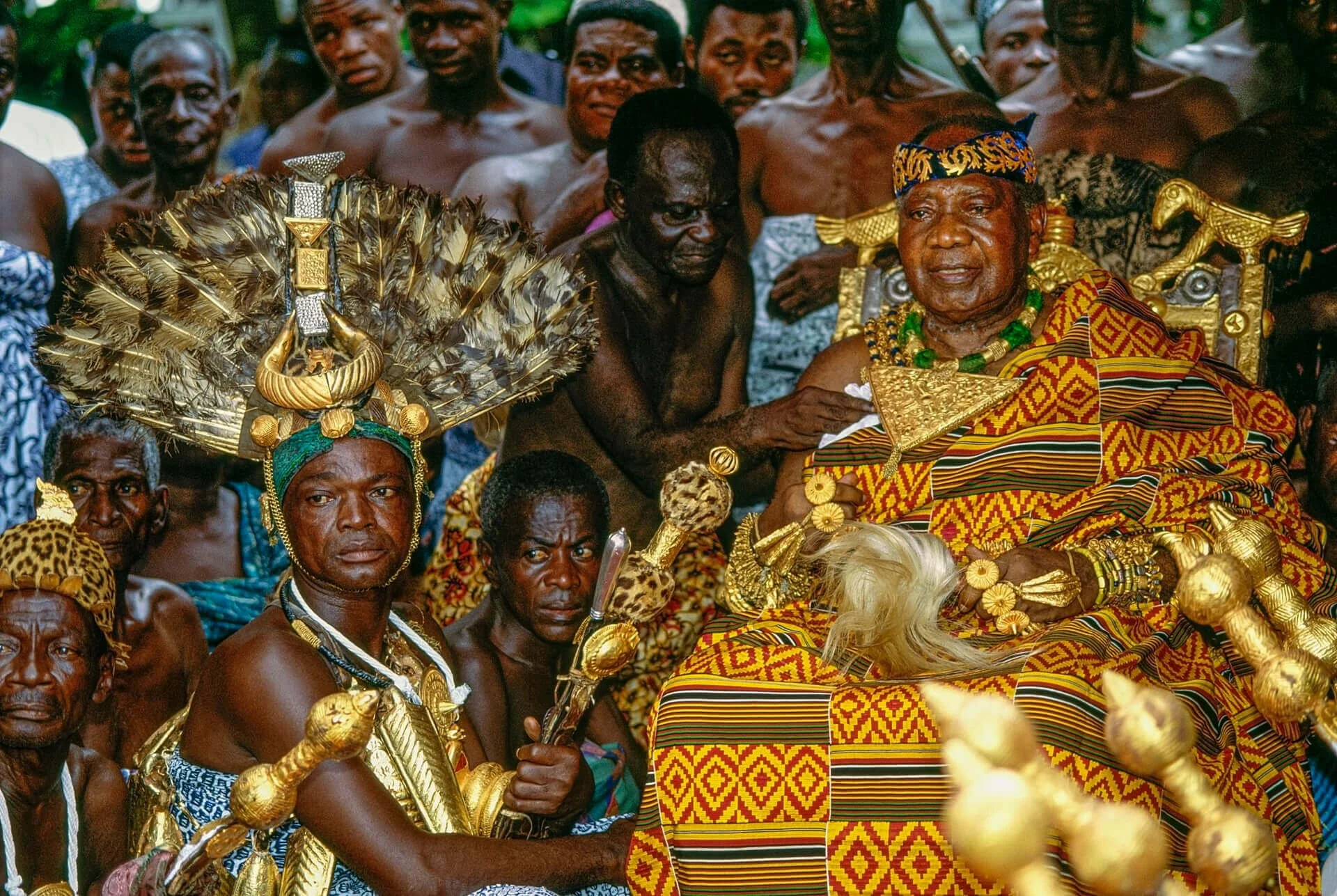Asantehene with Chief Sword Bearer, Ghana. Seated in state during the Jubilee, the Asantehene is adorned in richly woven Kente cloth—“the cloth that befits kings”—a textile that signifies prestige and encodes cultural knowledge through motifs tied to