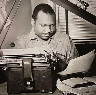 Richard Durham, writer and producer of Destination Freedom, a weekly radio program that aired on WMAQ in Chicago. The program aired from 1948 to 1950 which highlighted histories of African Americans like Harriet Tubman. Image of Richard Durham sittin