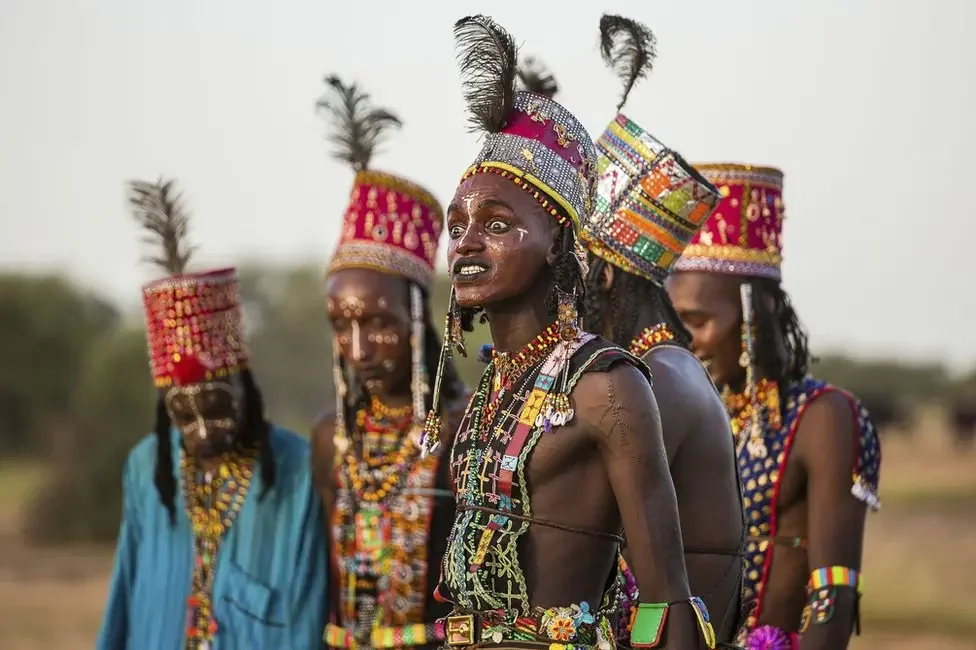 Wodaabe men grimace during the dance to show off their white teeth. By Tariq Zaidi. — Source: BBC