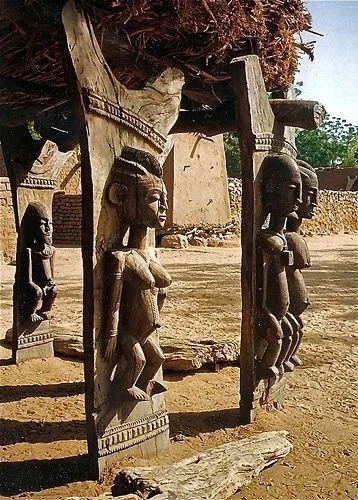 This image displays the carved wooden posts of a Dogon toguna (or "palaver hut") in Mali, West Africa. 
