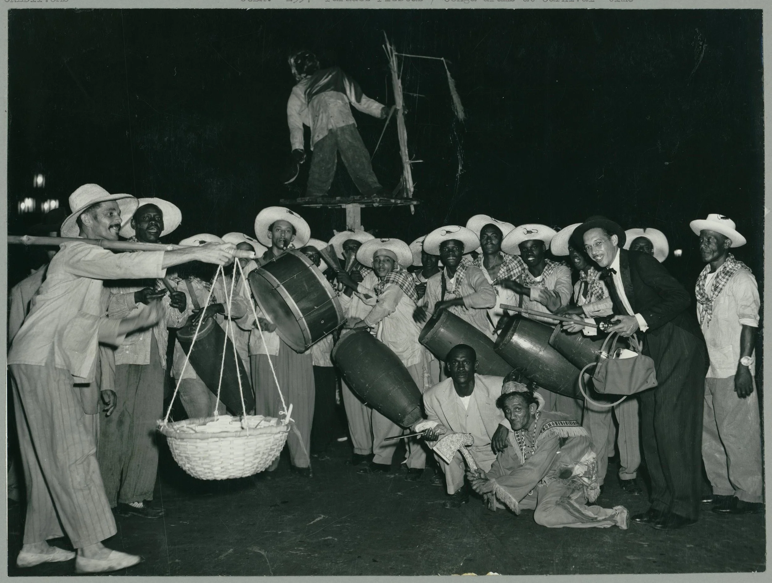 Conga Drums at Carnival Time. "This photograph from Cuba shows a group of male revelers in traditional costumes and large sombreros, with various types of drums and other musical instruments, in a Conga line. The conga is a dance that originated in C