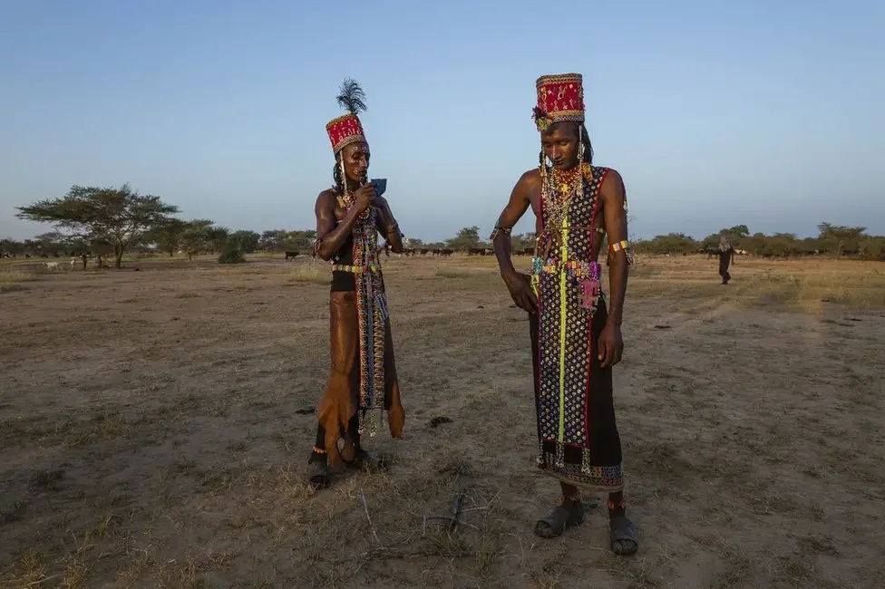 Two Wodaabe men take a break from dancing. By Tariq Zaidi. — Source: BBC