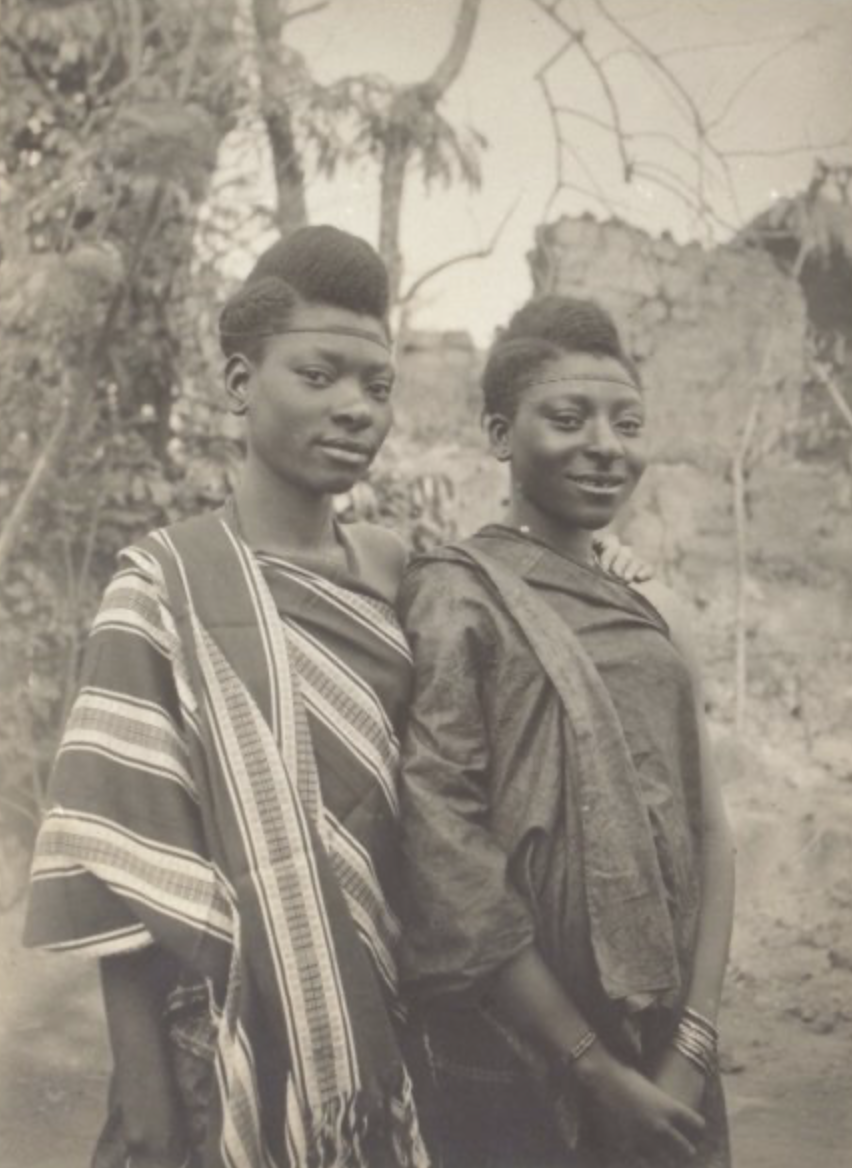 [Two young women standing outdoors in patterned garments] [Photograph]. Eccentric Yoruba. https://eccentricyoruba.wordpress.com/wp-content/uploads/2010/07/african-girls.jpg
