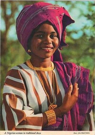 A young woman wearing an Aso oke, photographed by John Hinde, circa 1980s.