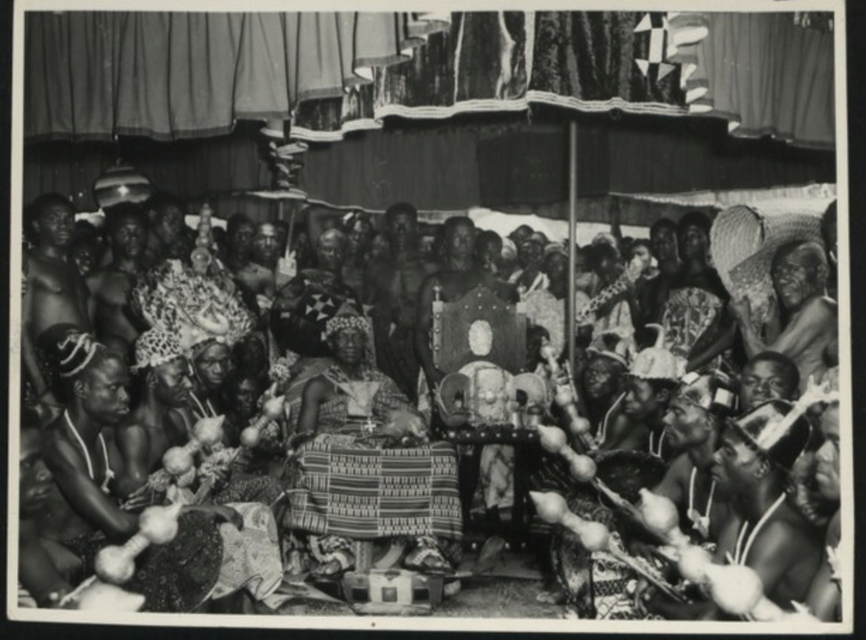 Coronation Durbar in Kumasi. Otumfuo the Asantehene is seen with the Golden Stool of Ashanti and members of his retinue [Photograph]. National Archives UK. Flickr. https://www.flickr.com/photos/nationalarchives/5416458290/in/album-72157625975820108/
