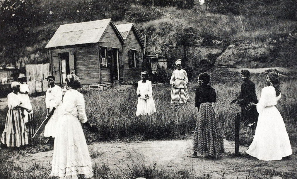 Women playing cricket on a cleared piece of scrubland in St Lucia (c. 1905) [Photograph]. In 100 years of photography in the Caribbean in pictures. The Guardian.