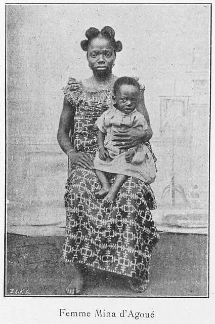 A black and white photo of a woman holding a baby ,  1900