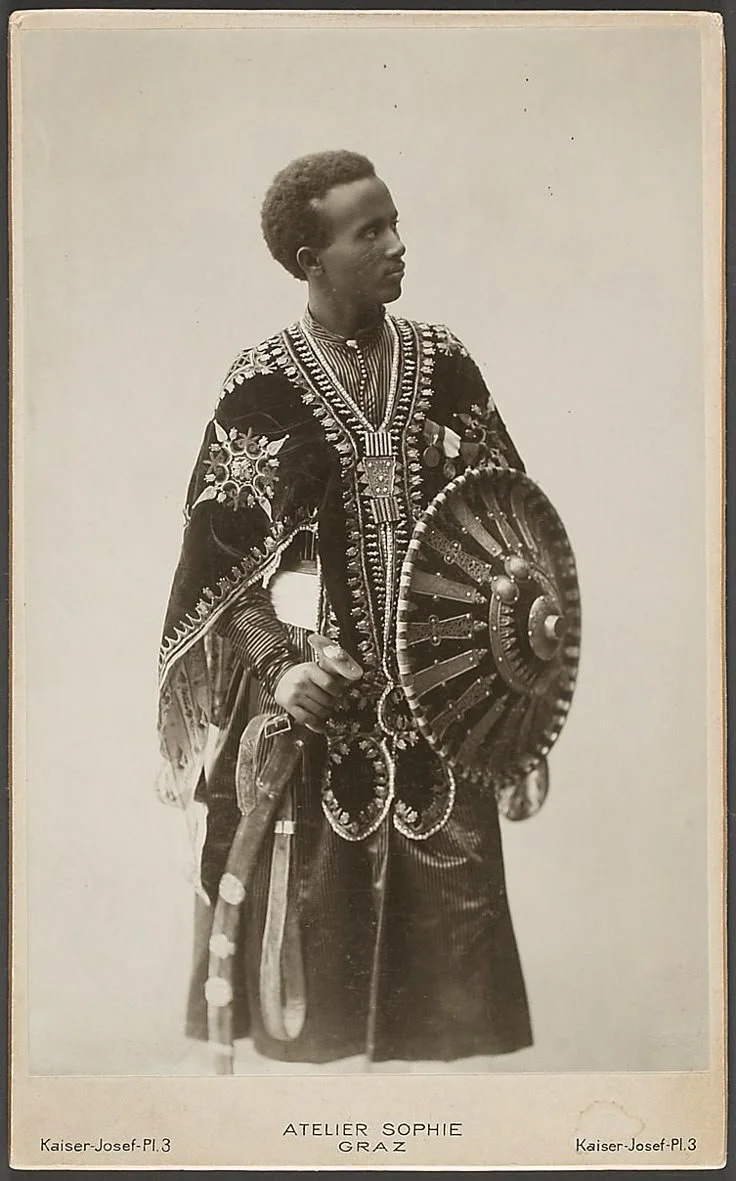 Portrait of Negadras Gebrehiwot Baykedagn, an Ethiopian intellectual and economist in traditional Ethiopian warrior attire, with an ornate shield (known as a Gasha). 