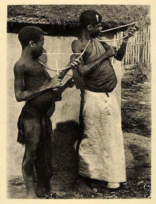 1930 photogravure of two Ngangela boys playing mouthbows. Angola, Africa.
Photograph by Alfred Schachzabel.