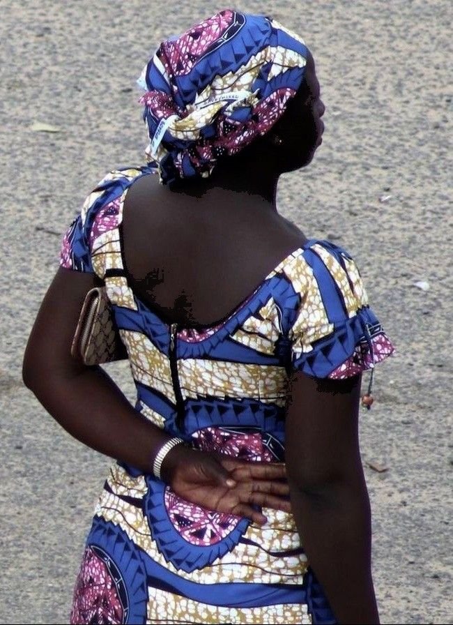 West African woman wearing a dress and headwrap made of Ankara fabric.