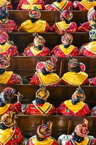 Women in Guadeloupe seated together wearing madras headwraps and traditional Creole dresses.
