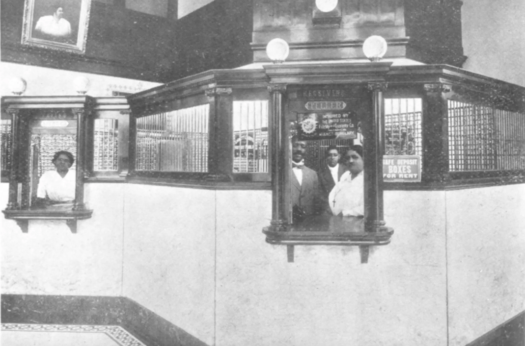 The St. Luke Penny Savings Bank was opened by Maggie Lena Walker (pictured, center-right) and became the longest running Black-owned bank in Jackson Ward and the United States.