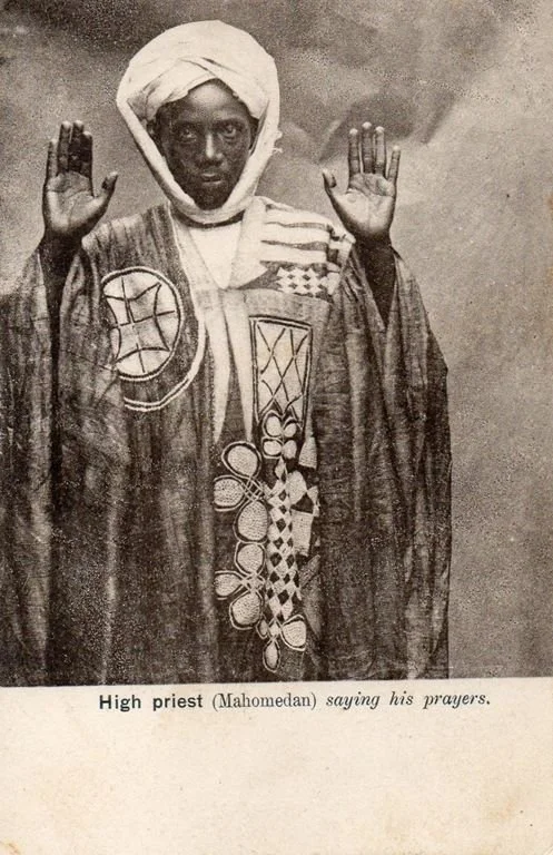  An Imam in Sierra Leone, photographed around 1902, prays in a prestigious indigo etu robe with eight-knives embroidery and a narrow-strip cotton turban.