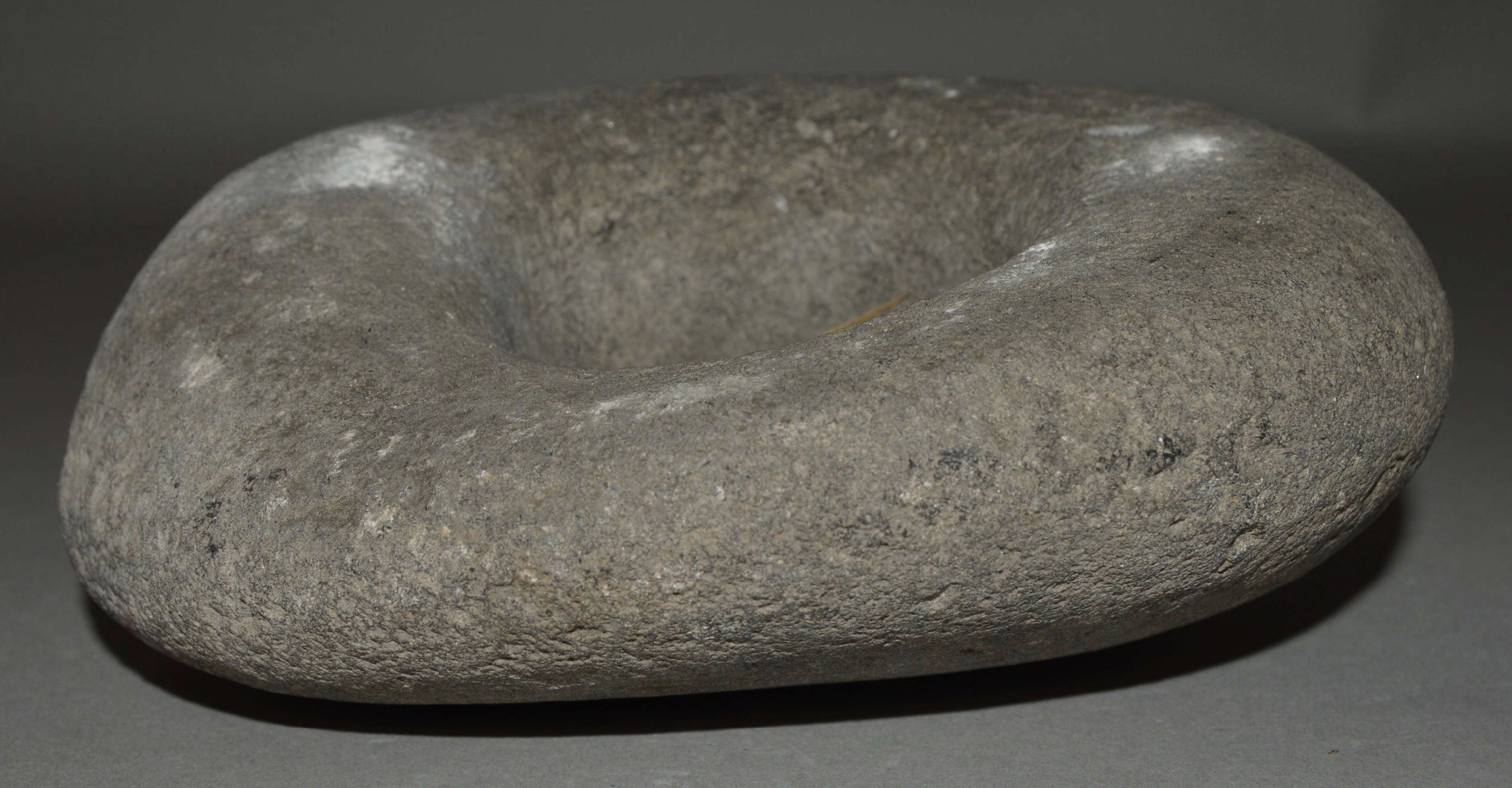 Stone Bowl or Grindstone. Stone; Height 7.50 cm × Width 18 cm × Depth 16.50 cm; Weight 2.24 kg. Caribbean, Americas. This heavy stone object is identified in the museum record as either a bowl or a grindstone. Its broad surface area, substantial weig