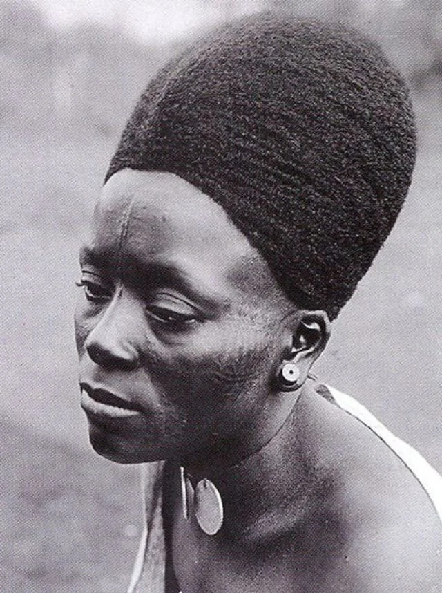 Traditional, high-crowned Mangbetu hairstyle that aligns with elongation as a beauty standard. Sourced from Vintag.es.